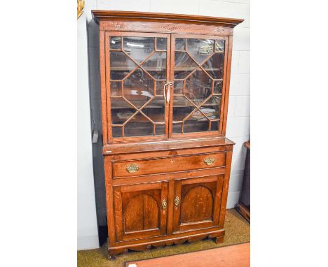 A George III Oak Bookcase, with an astragal glazed top with inlaid frieze, raised on a cupboard base with single drawer, with
