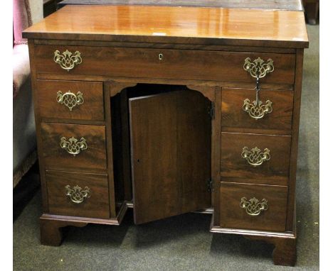 A George III Style Mahogany Dressing Table, with central cupboard and on bracket supports, 86cm by 45.5cm by 76cm