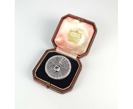 An Art Deco diamond set brooch attributed to Cartier, designed as a central principle old cut diamond mounted within a pave o