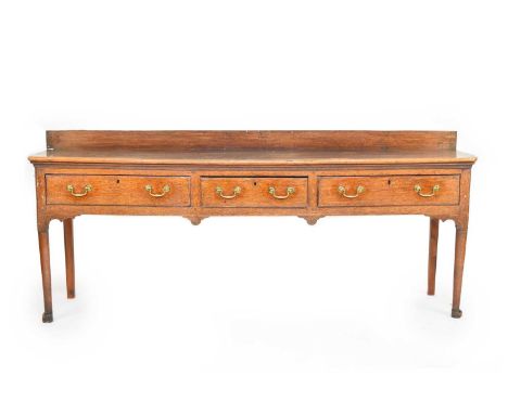 A George III oak dresser baseThe rectangular 3-plank top with a ledge back, above 3 frieze drawers with brass swan neck handl
