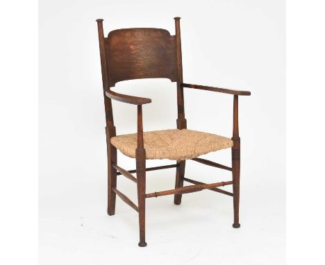 An Arts and Crafts style rush-seated oak armchairAfter a design by E.G. Punnett and likely made by William Birch, with arched