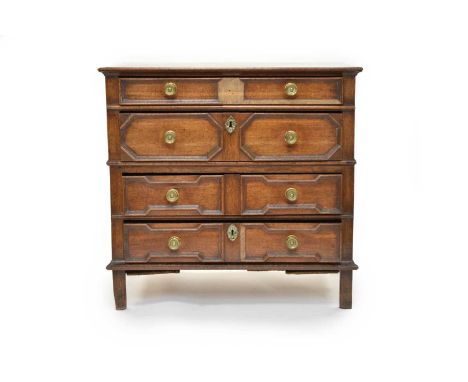 A Jacobean oak chest of four drawersThe three plank cleated top above a shallow recessed panel of drawer, over three further 
