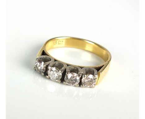 A four stone diamond ring, the four uniform brilliant cut diamonds claw set in white metal to yellow metal shank, ring size N