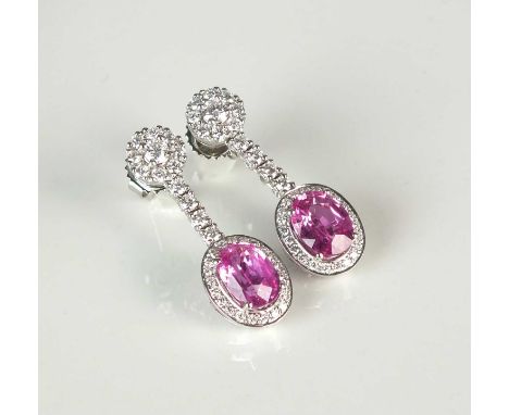 A pair of 18ct white gold pink sapphire and diamond ear pendants, each designed as a single oval mixed cut pink sapphire claw