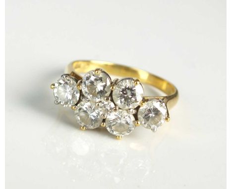 An 18ct gold seven stone diamond dress ring, designed a central raised brilliant cut diamond claw set within six further bril