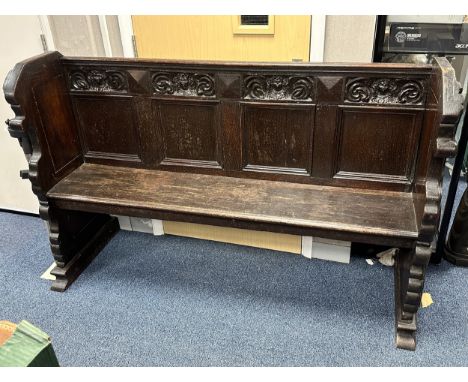 Carved Dark Oak Pew. Panelled backrest, with ornate carvings. Both ends carved. W157cm x D53cm x H100cm. BUYER TO COLLECT OR 
