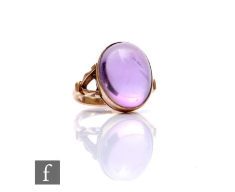 A 9ct single stone amethyst ring, oval cabochon collar set stone, length 16mm, to split shoulders, weight 6g, ring size L.