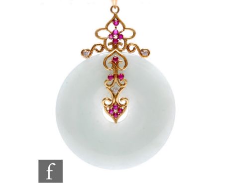A circular carved jade pendant to a 14ct ruby and diamond ornate pendant mount, total weight 29.5g, diameter 60mm.