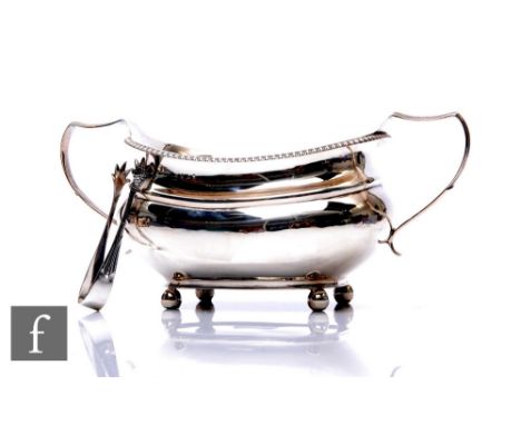 A Georgian hallmarked silver boat shaped twin handled sugar basin with gadroon border and a pair of sugar tongs, total weight
