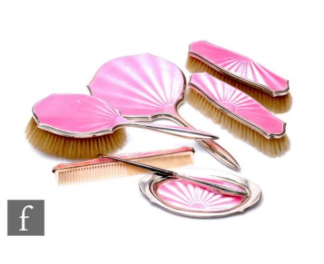 A hallmarked silver and pink enamel decorated seven piece brush set to include hand mirror pin tray, three brushes and a comb