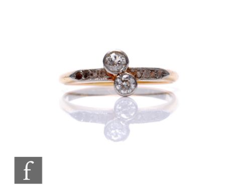 An 18ct diamond two stone cross over ring to diamond set shoulders, weight 2.4g, ring size M, some damage.
