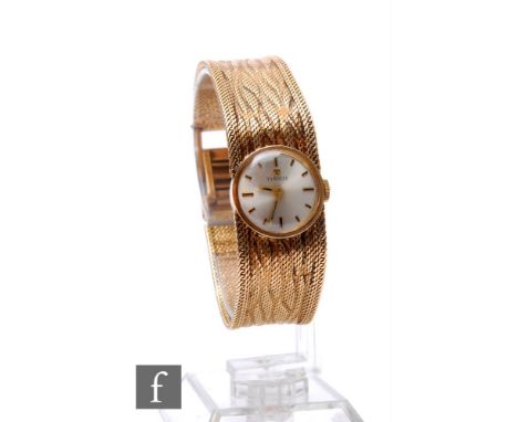 A 9ct hallmarked lady's Tissot manual wind wrist watch, gilt batons to a circular silvered dial and integral mesh link bracel