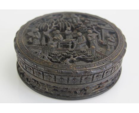 A 19th Century Chinese carved tortoiseshell snuff box of circular form, decorated in low relief of figures in garden settings