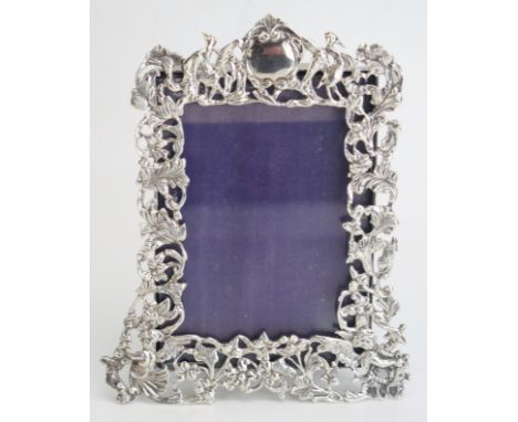 A Victorian silver easel photograph frame, maker William Comyns &amp; Sons, London, 1892, of arched outline with pierced foli