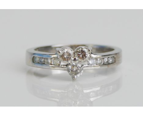 A Platinum Three Stone Diamond Ring with diamond set shoulders, size K.5, 3.7gms