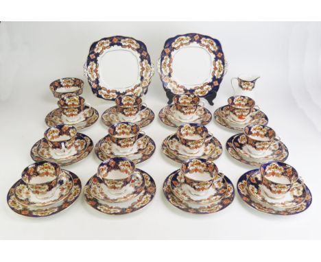 An Edwardian tea service with floral decoration in the Imari style, includes twelve tea cups, twelve saucers, twelve side pla
