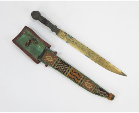 A Nigerian Yoruba tribe dagger, with 27cm single edged brass blade, turned wood grip, contained in a leather and woven sheath