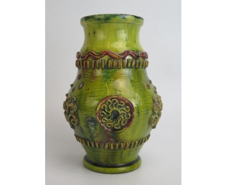 An Edward Bingham for Castle Hedingham pottery vase of ovoid form, with applied roundel and scroll motifs, on a circular foot