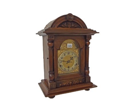 German walnut three train mantel clock, the movement striking on five rods, the 5" brass arched dial with silvered chapter ri