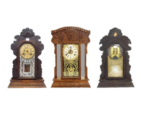 American carved oak gingerbread two train mantel clock striking on a bell and gong, the 5" cream dial within a decorative gla