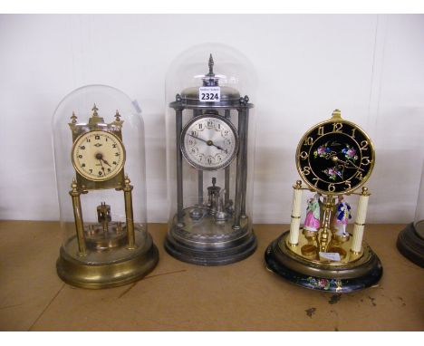 White metal torsion clock, the 3.25" silvered dial within a temple pillared case and under a glass dome upon a stepped circul