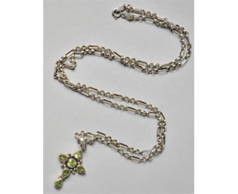 A Silver and Peridot Jewelled Crucifix on a Silver Chain. 