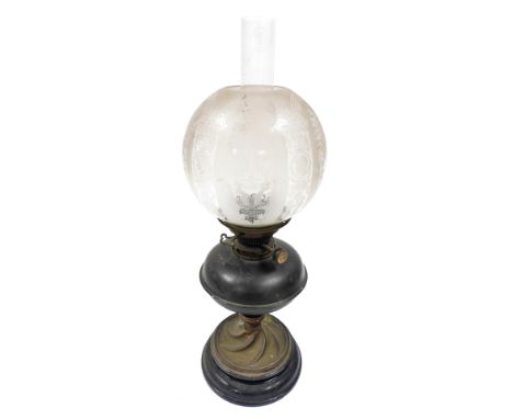 A late 19th/early 20thC oil lamp, with a clear and etched glass shade, brass central reservoir, on a twisted brass stem termi