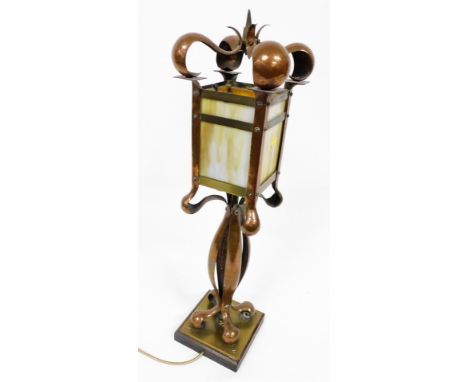 An early 20thC copper and brass Art Nouveau electric table lamp, the lantern shaped shade with opaque marbled panels, on a sh