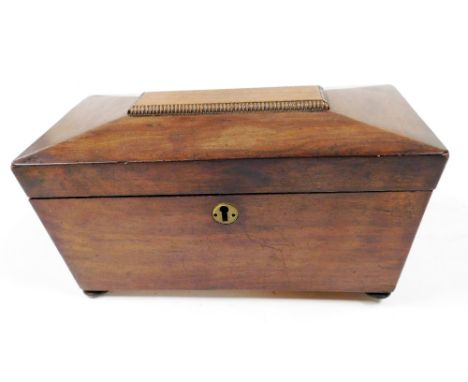 A Regency mahogany sarcophagus shaped tea caddy, the hinged lid enclosing two separate lidded divisions, on bun feet, 29cm wi