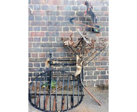 A wrought metal weather vane, with a horse and jockey finial, 144cm high, a wrought metal wall mounted hayrack, 94cm wide, an