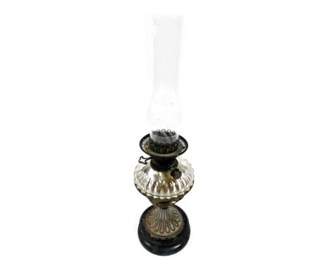 A 19th/early 20thC oil lamp, with a central glass reservoir resting on brass basket support, on a socle, with chimney, 59cm h