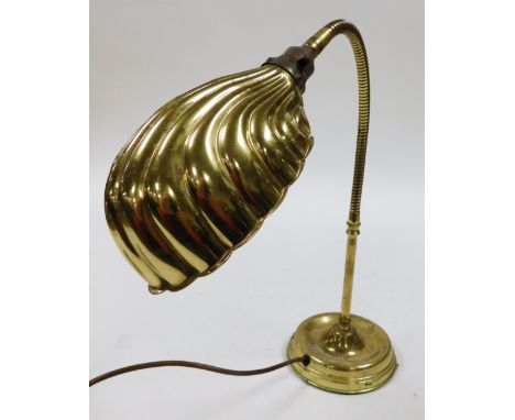 A brass effect desk lamp, with shell shaped shade, adjustable column and domed foot, 75cm high. 