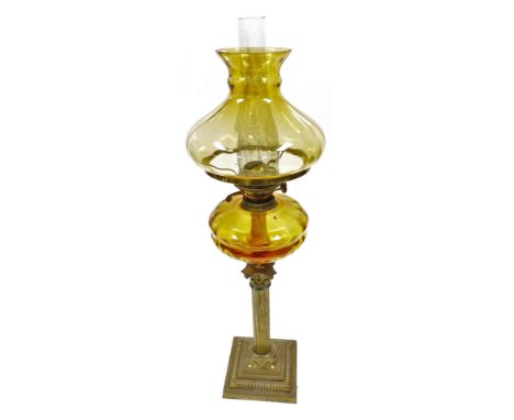 A late 19th/early 20thC Duplex oil lamp, with an amber coloured glass shade and amber glass reservoir, on a brass Corinthian 
