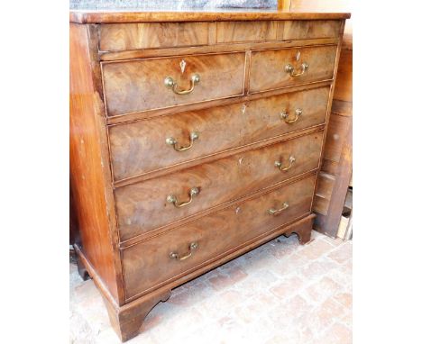 A George III mahogany chest of drawers, with a secret frieze drawer above two short over three long drawers, each with brass 