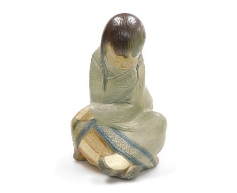 A Lladro matte porcelain figure of an Eskimo girl, in seated position, printed and impressed marks, 30cm high. 