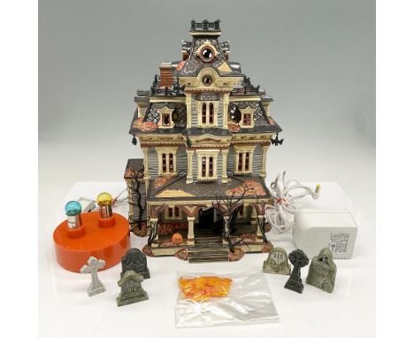 Hand painted haunted mansion with plug in accessory to light it. Overgrown bare trees, bats and pumpkin on porch add to this 