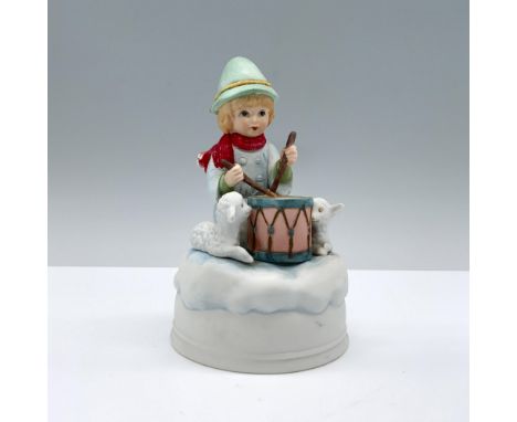 A matte figurine portrays the little drummer boy playing his drum, with two sheep beside him, all atop a cloud base. Mann man