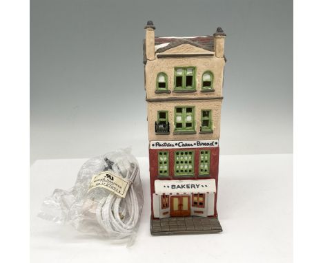 Part of the Heritage Village Collection, brownstone building in red and green with signs advertising their baked goods. Light