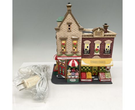 Hand painted storefront with holiday decorations and snow on roof. Store lights with plug in accessory. Department 56 impress