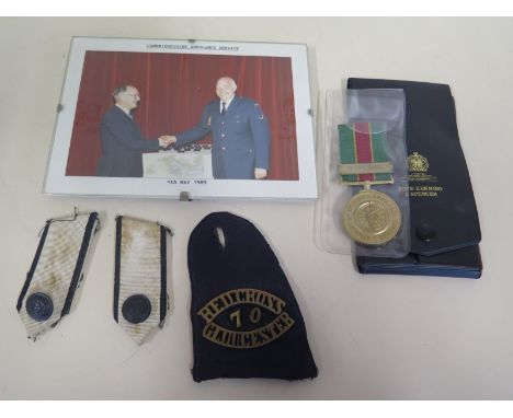 An ambulance service medal, a Red Cross epaulette with 70 Gloucester metal badge, buttons and photograph of a Cambridgeshire 