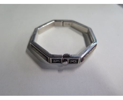 A silver bangle of octagonal form, approx 5.2cm internal diameter, approx 1.6 troy oz, signs of wear throughout 