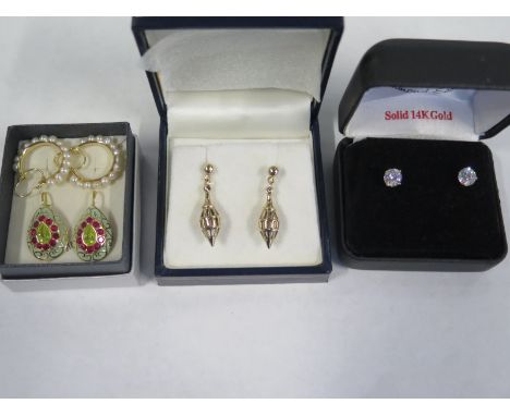 A pair of 9ct gold lantern earrings, a pair of 14ct zirconia earrings, a pair of enamel and gold earrings, and a pair of pear