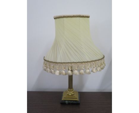 A brass table lamp with a Corinthian column mounted on an Onyx base, with period shade, 48cm H 