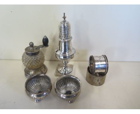 A silver sifter, two silver napkin rings, a pair of silver salts and a silver and a glass grinder, total silver weight approx