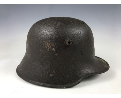 A relic Imperial German steel helmet exhibiting fractures