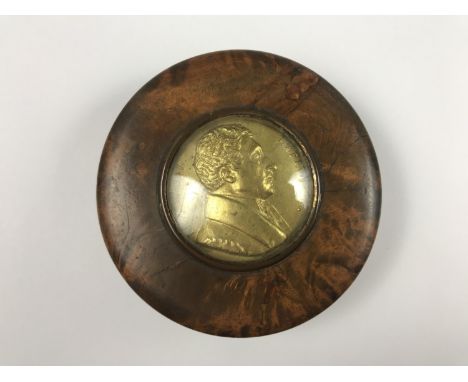 An early 19th Century French burr wood snuff box, the lid inset with a gilt metal plaque bearing a relief profile portrait of