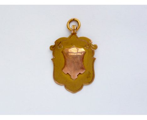 A George V 9ct gold shield-shaped fob, engraved verso 'C A / J W &amp; R Atkinson', 3.4g
