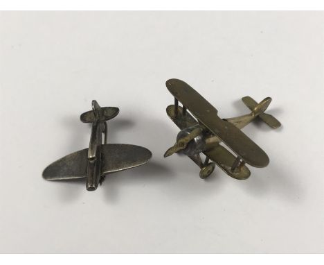 An extremely small scale brass model Sopwith Camel aircraft, together with a brooch in the form of an RAF Spitfire, 3 cm and 