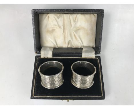 A cased pair of George VI silver napkins, having engine turned banded decoration, John Rose, Birmingham, 1948, 53g