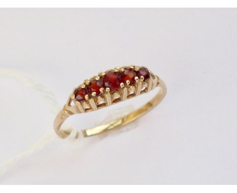 A vintage five-stone garnet ring, the round-cut stones being claw-set in a graded arrangement above a reticulated gallery, 1.